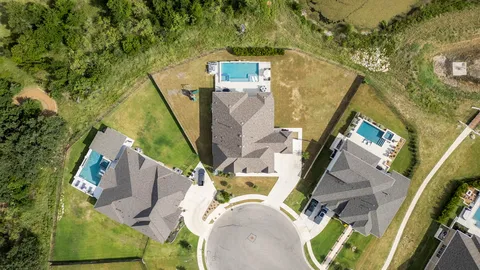 an aerial view of a house with a yard and a wooden bridge
