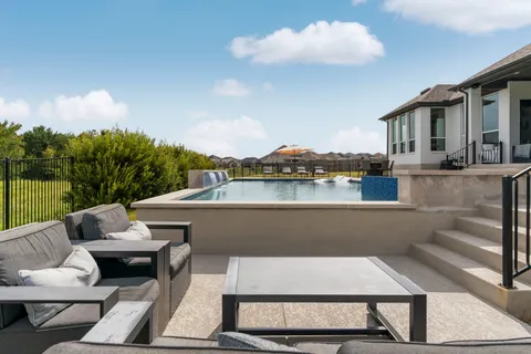 a view of a patio with couches table and chairs with wooden floor and fence