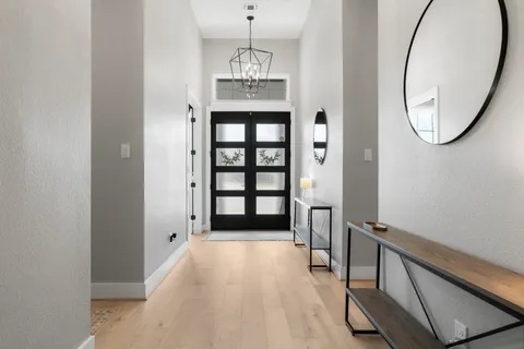 a view of a hallway with wooden floor and entryway