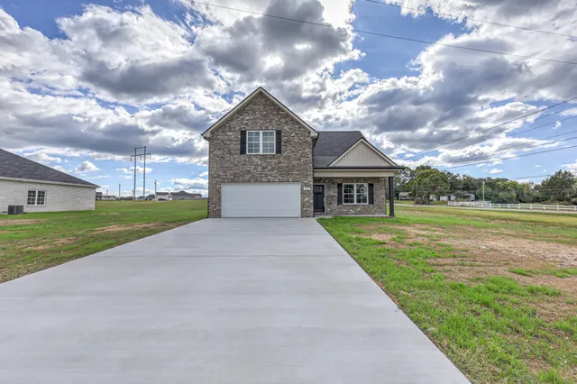 a front view of a house with yard and green space