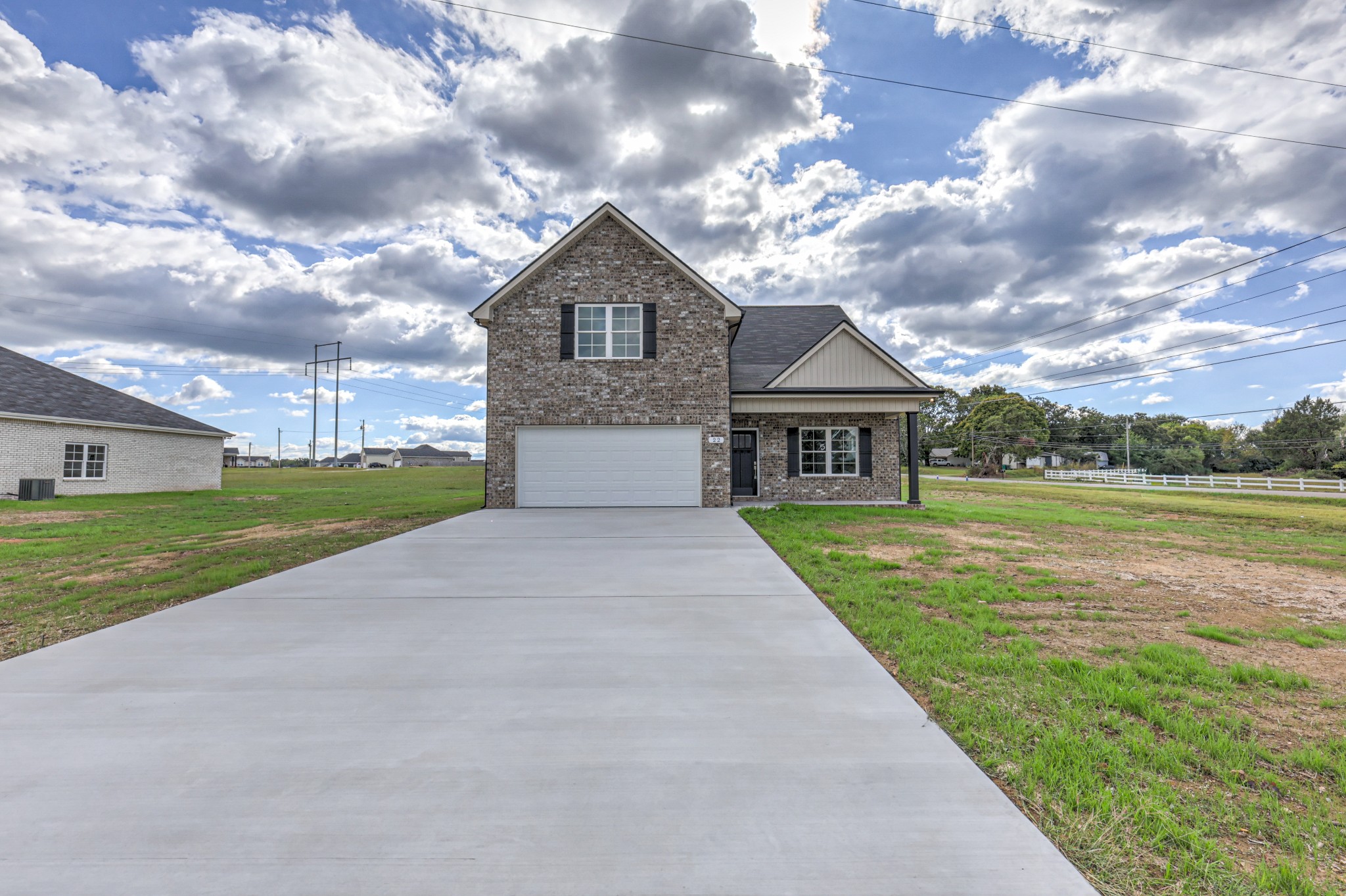 a front view of a house with yard and green space