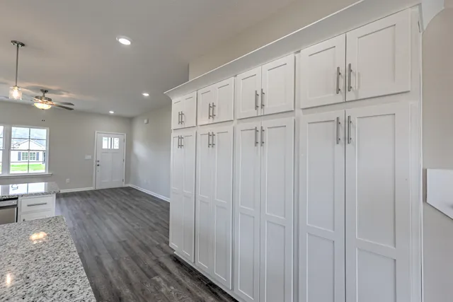 a kitchen with stainless steel appliances granite countertop a kitchen island a stove a cabinets a sink and a wooden floors