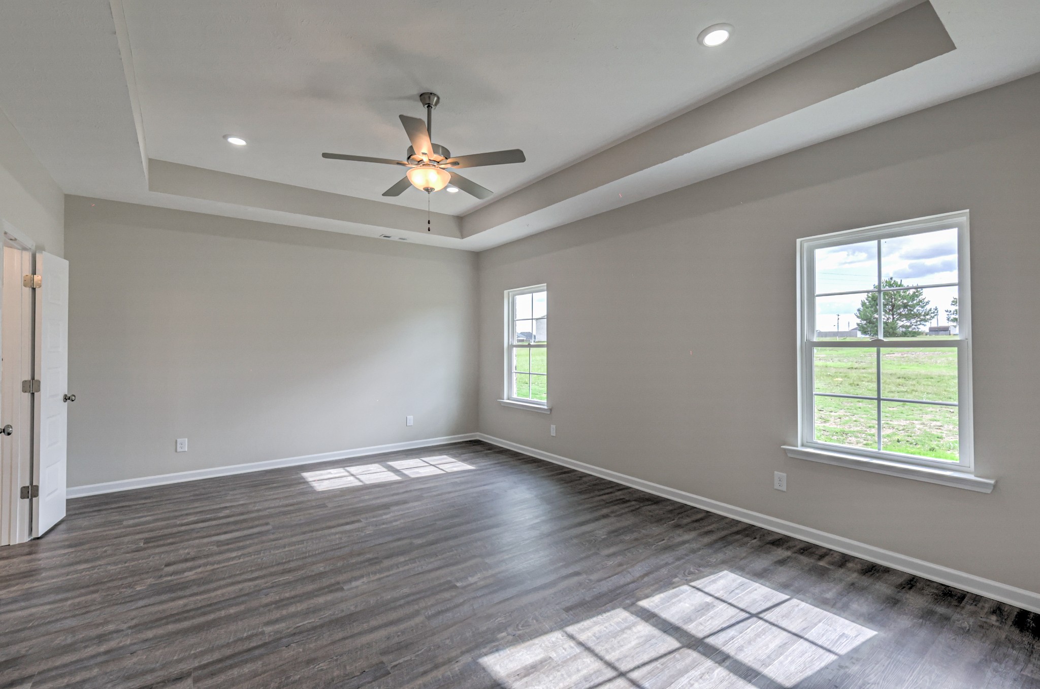22 Bartow Street Decherd, TN 37324 - Photo 16 of 38 an empty room with wooden floor chandelier fan and windows