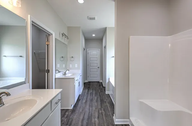 a bathroom with a double vanity sink a mirror and a bathtub