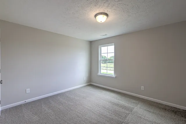 an empty room with closet and windows