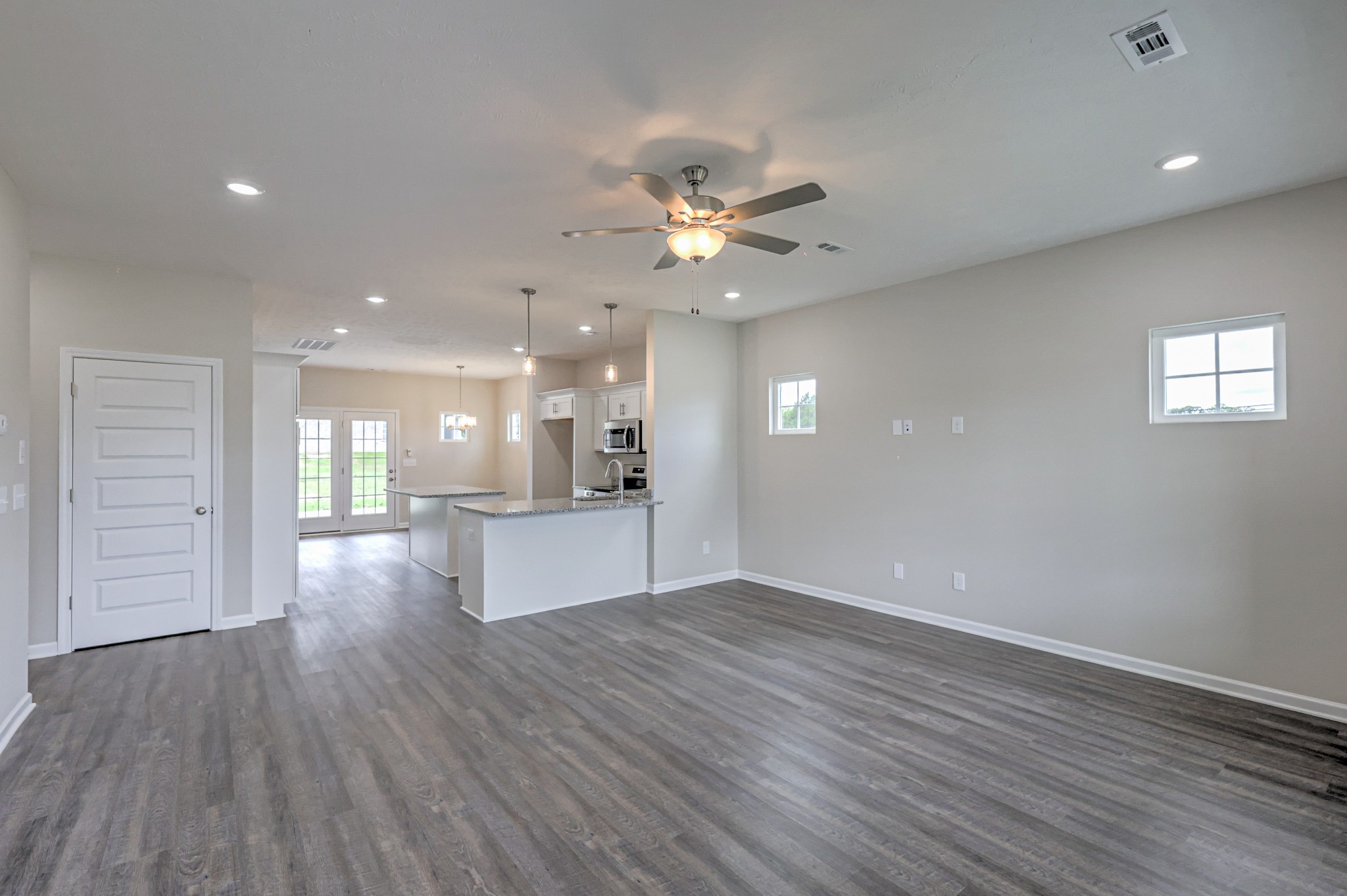 22 Bartow Street Decherd, TN 37324 - Photo 5 of 38 a view of an empty room and kitchen with wooden floor