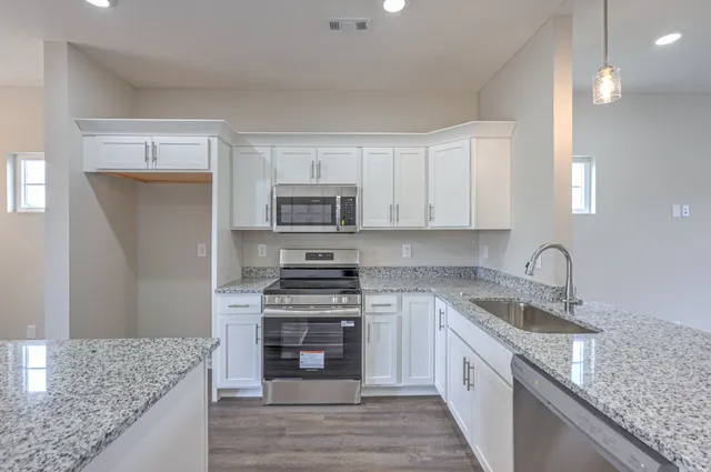 a kitchen with stainless steel appliances granite countertop a sink stove and refrigerator