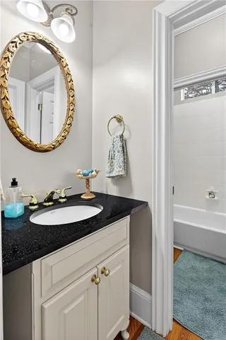 a bathroom with a tub a sink and a large mirror
