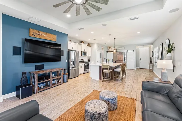 a kitchen with stainless steel appliances kitchen island granite countertop a table chairs and a refrigerator