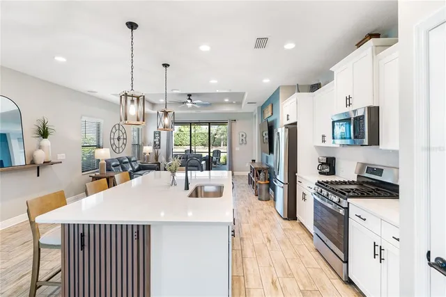 a kitchen with stainless steel appliances a refrigerator a stove a sink and a island