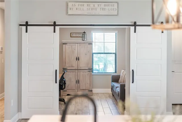 a view of a kitchen with refrigerator and wooden floor