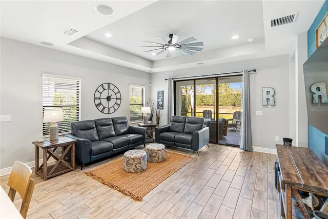 a kitchen with stainless steel appliances kitchen island granite countertop a dining table chairs sink refrigerator and microwave