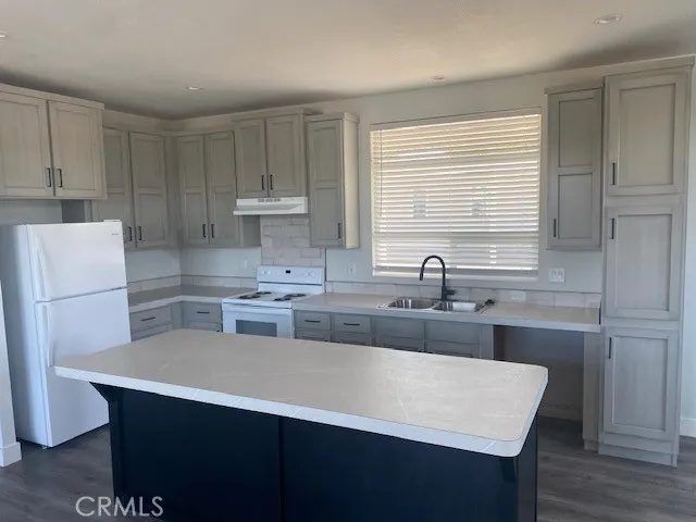 a kitchen with a sink a stove a refrigerator and cabinets