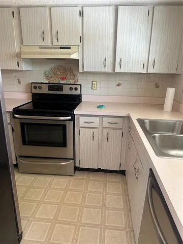 a kitchen with a sink stove and cabinets