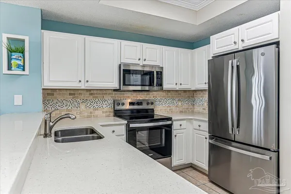 a kitchen with a refrigerator sink and stainless steel appliances