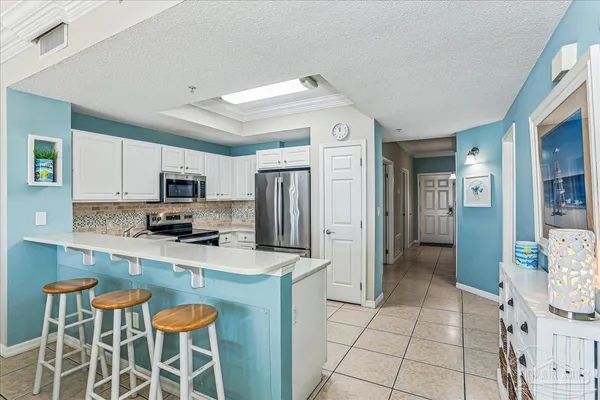 a kitchen with stainless steel appliances a stove a sink cabinets and a refrigerator