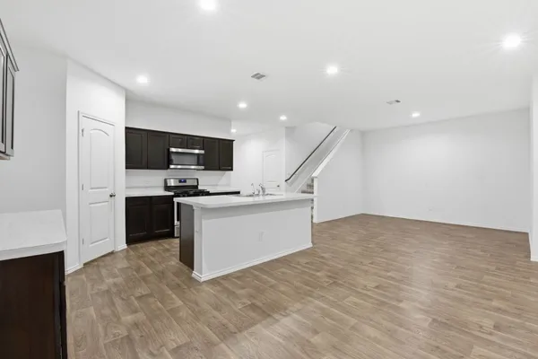 a view of kitchen with microwave oven stove and cabinets