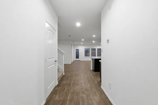 a view of a hallway with wooden floor and staircase