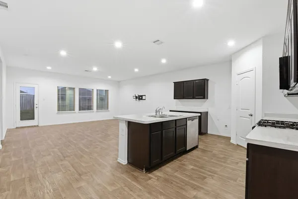 a large kitchen with stainless steel appliances a stove and a refrigerator