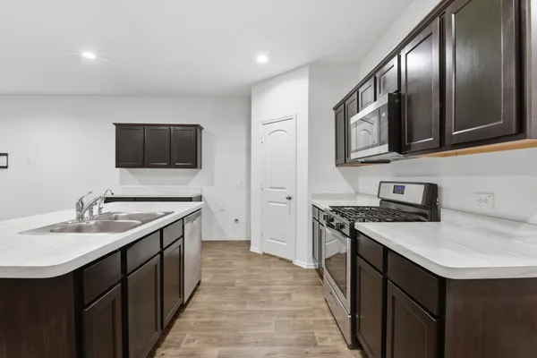 a kitchen with a sink stove and microwave