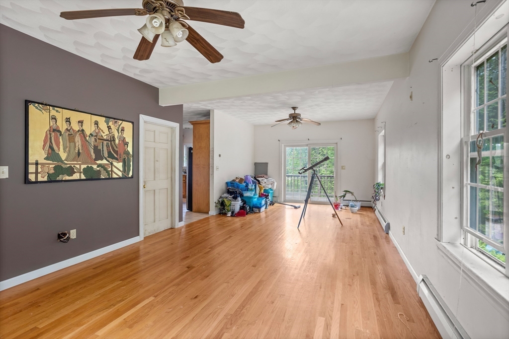 85 Wheeler Road Princeton, MA 01541 - Photo 9 of 28 a view of a livingroom with wooden floor and a ceiling fan