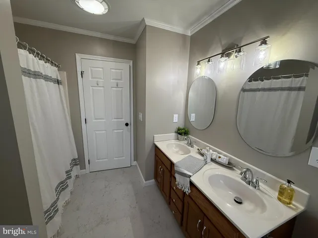 a bathroom with a double vanity sink mirror and shower