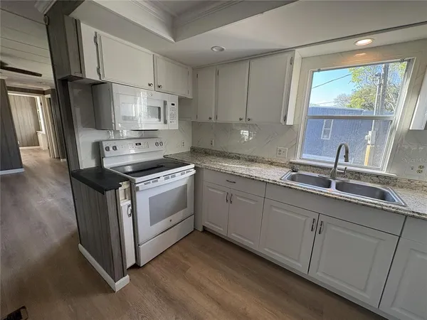 a kitchen with stainless steel appliances white cabinets a sink and a stove