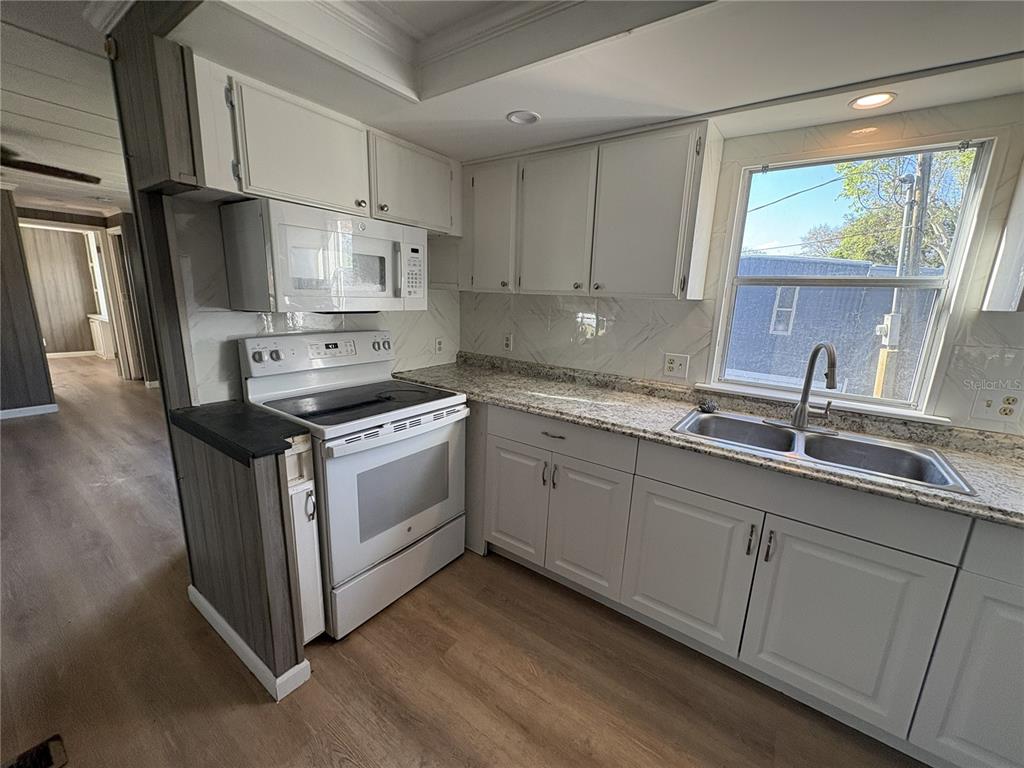 1183 9th Street Okeechobee, FL 34974 - Photo 2 of 14 a kitchen with stainless steel appliances white cabinets a sink and a stove