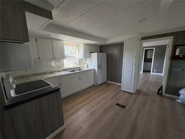 a kitchen with a sink cabinets stainless steel appliances and a window