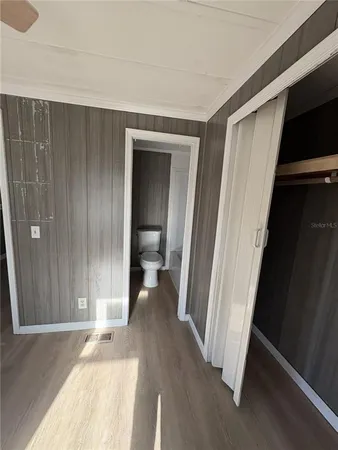 a view of a room with wooden floor and a bathroom
