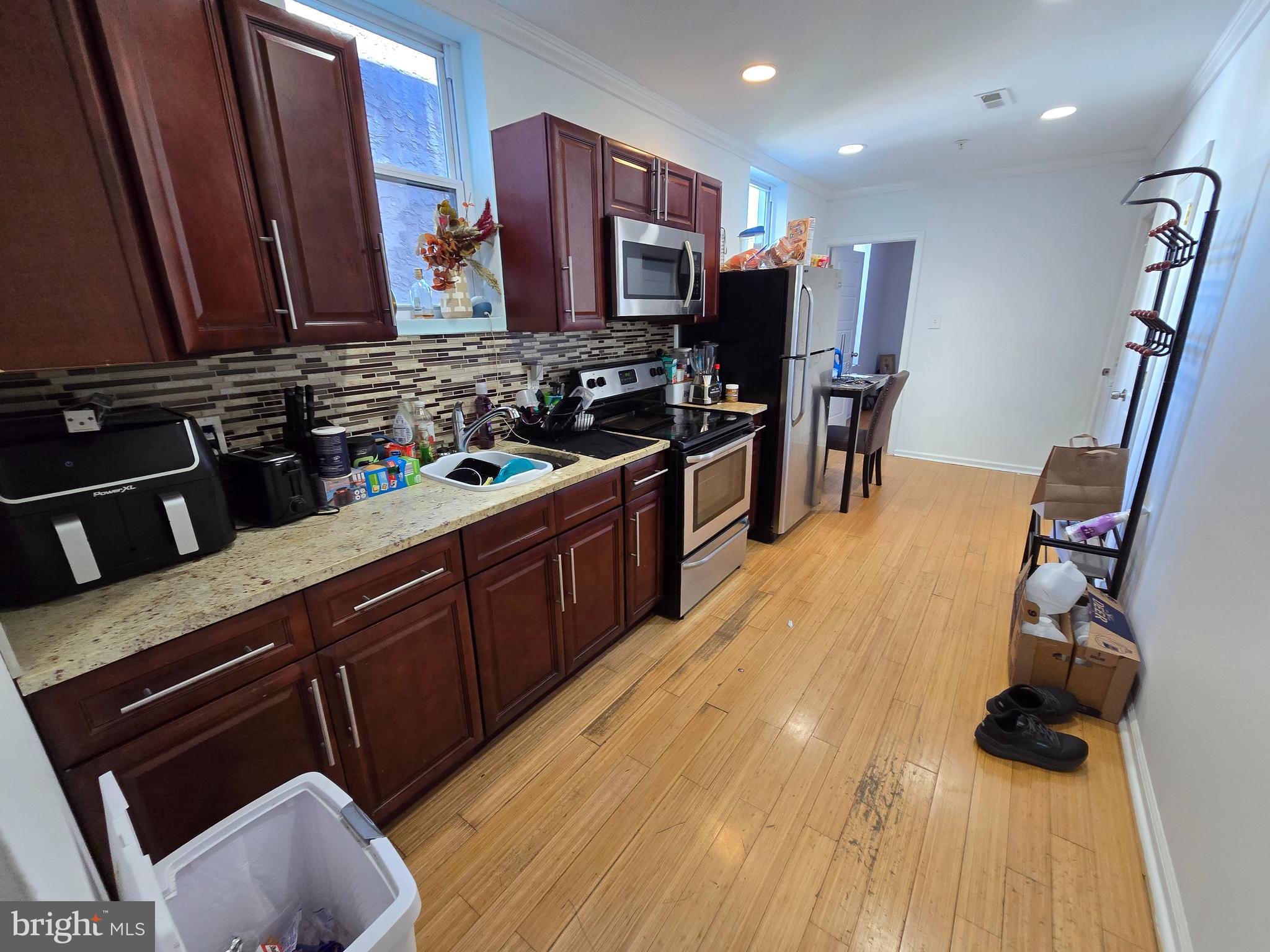 1833 Master Street Philadelphia, PA 19121 - Photo 3 of 22 a kitchen with stainless steel appliances granite countertop a sink dishwasher stove and refrigerator with wooden floor