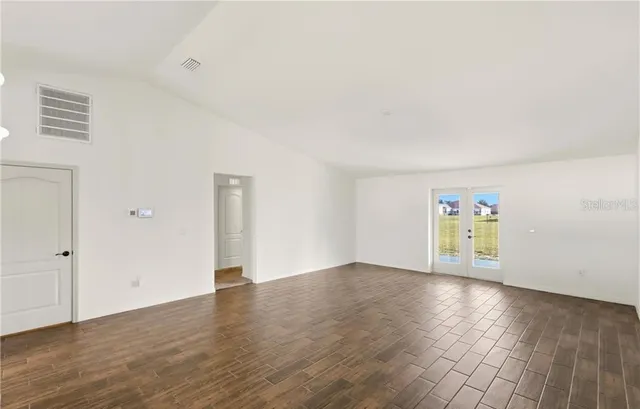 a large white kitchen with a refrigerator a sink dishwasher and a stove with wooden floor