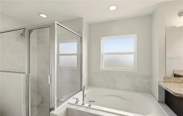 a en suite bathroom with a granite countertop sink and a mirror
