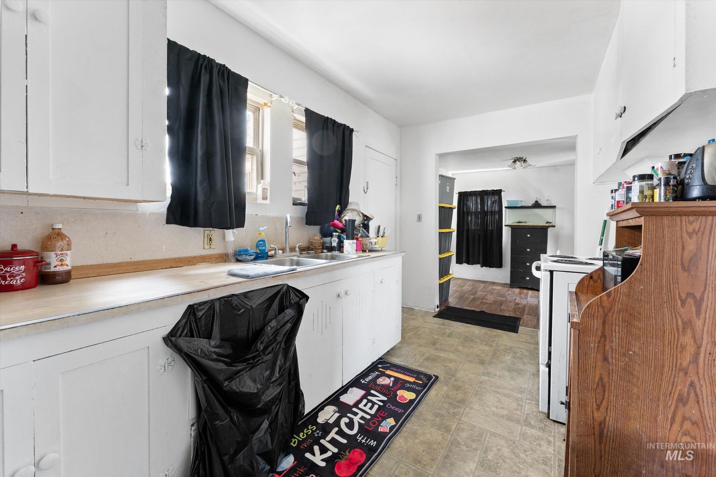 20286 Travis Road Wilder, ID 83676 - Photo 11 of 48 Kitchen with light countertops, white cabinetry, and white range oven