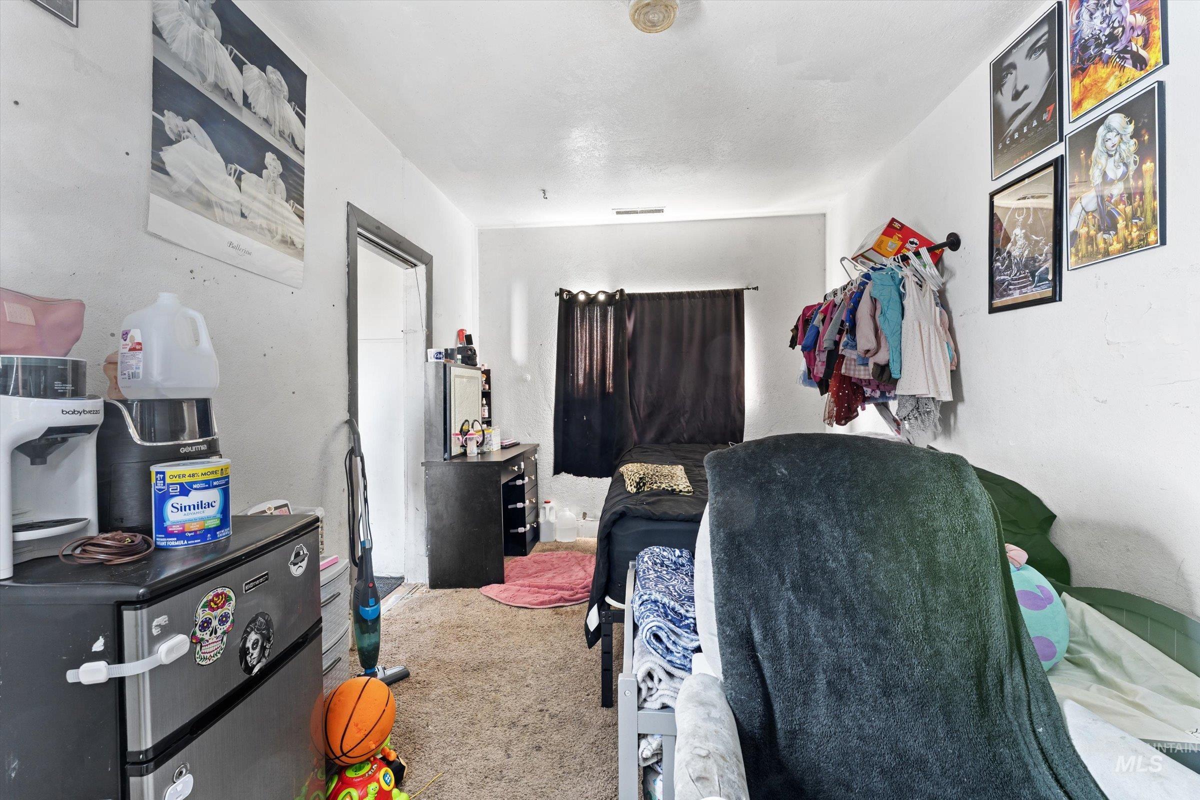 20286 Travis Road Wilder, ID 83676 - Photo 17 of 48 Bedroom featuring stainless steel fridge and carpet floors