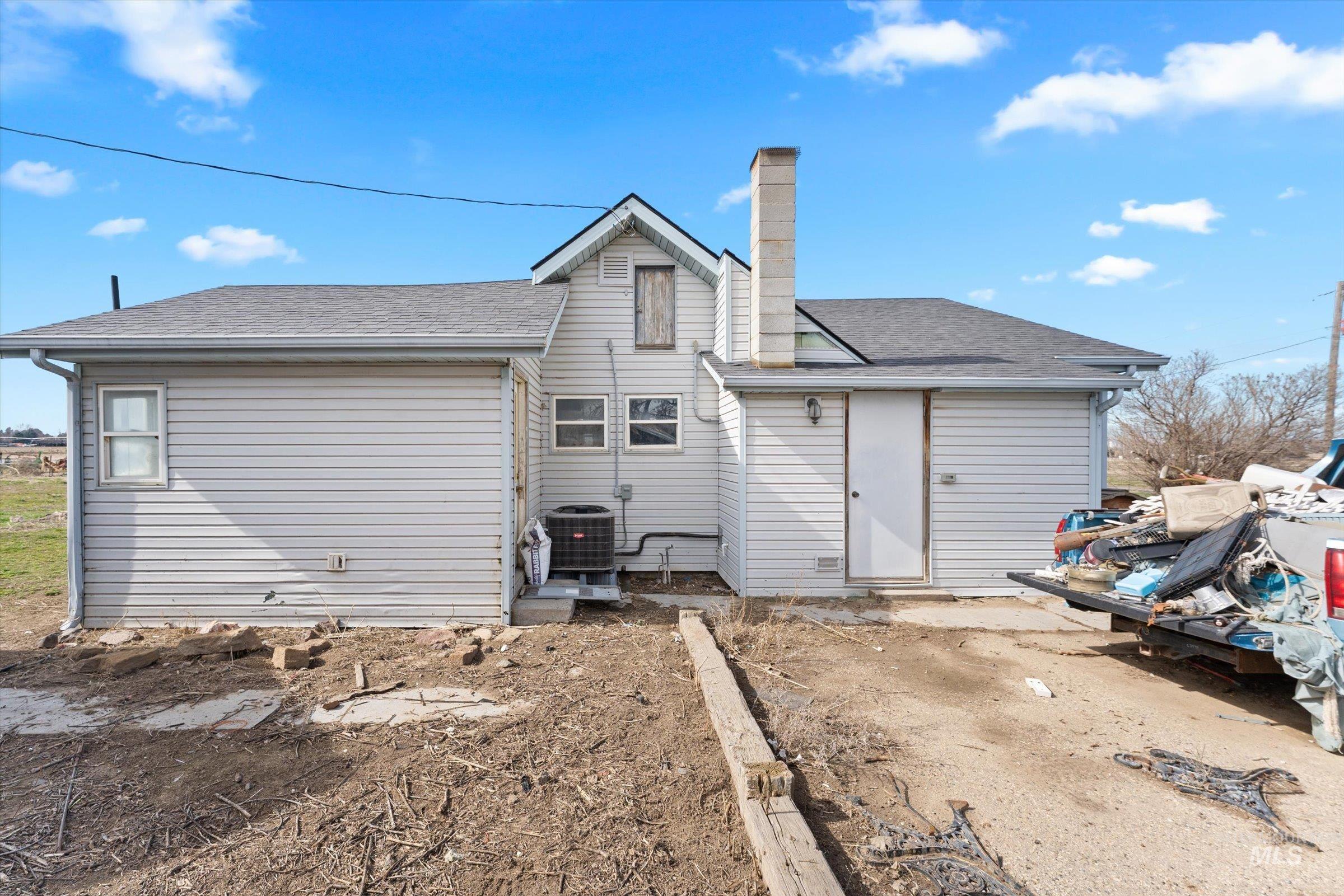20286 Travis Road Wilder, ID 83676 - Photo 4 of 48 Rear view of property featuring a chimney and roof with shingles