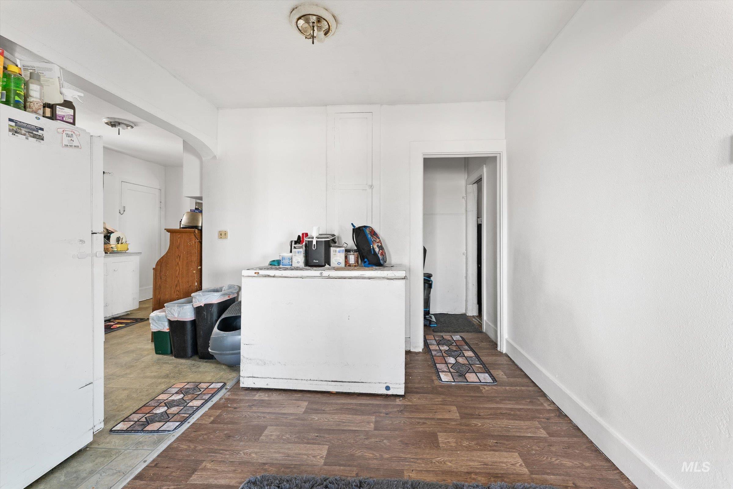 20286 Travis Road Wilder, ID 83676 - Photo 9 of 48 Kitchen featuring freestanding refrigerator, arched walkways, dark wood finished floors, white fridge, and light countertops