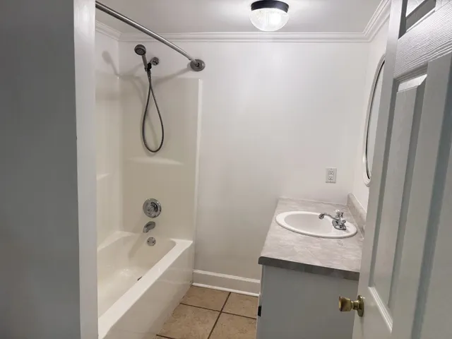 a bathroom with a granite countertop bathtub shower sink and vanity