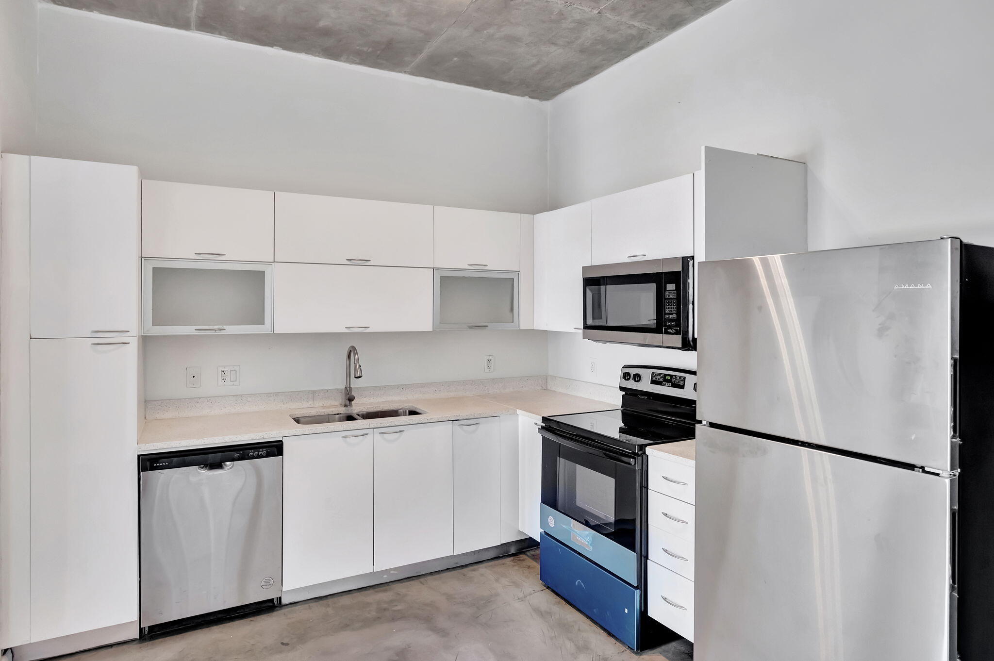 234 Northeast 3rd Street, Unit 2206 Miami, FL 33132 - Photo 12 of 30 a kitchen with a refrigerator sink and white cabinets