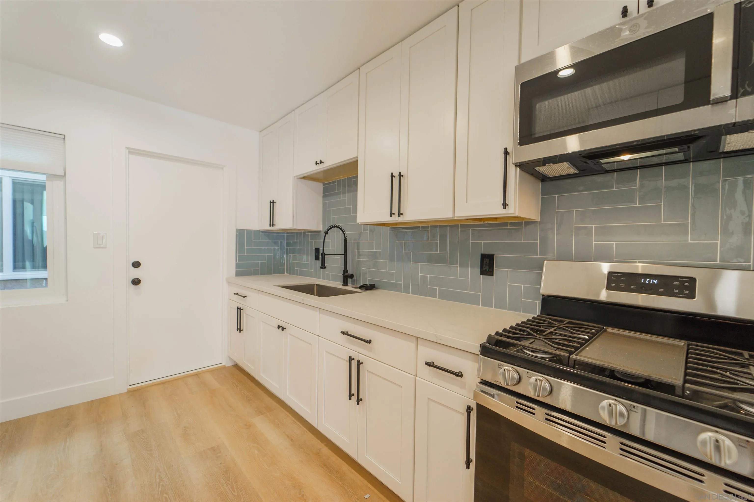 4518-24 Kansas Street San Diego, CA 92116 - Photo 19 of 33 a kitchen with a stove and white cabinets