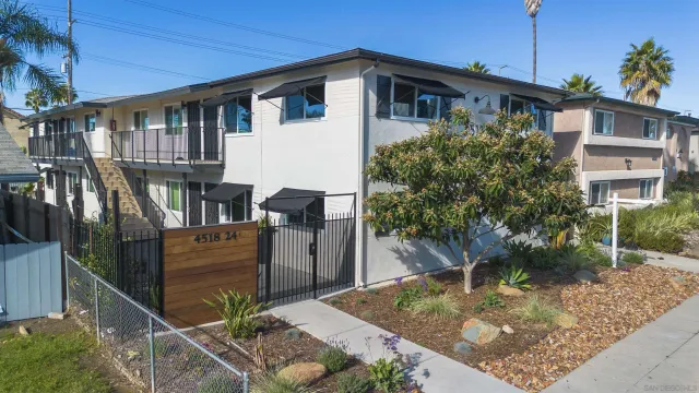 a view of a house with a small yard and potted plants