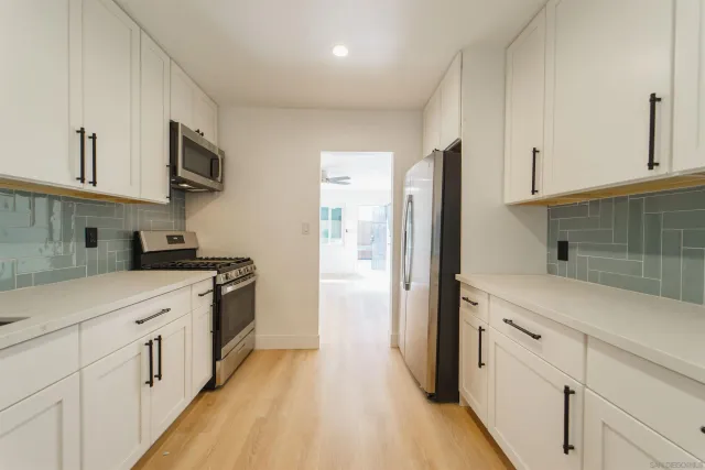 a kitchen with a refrigerator sink and cabinets
