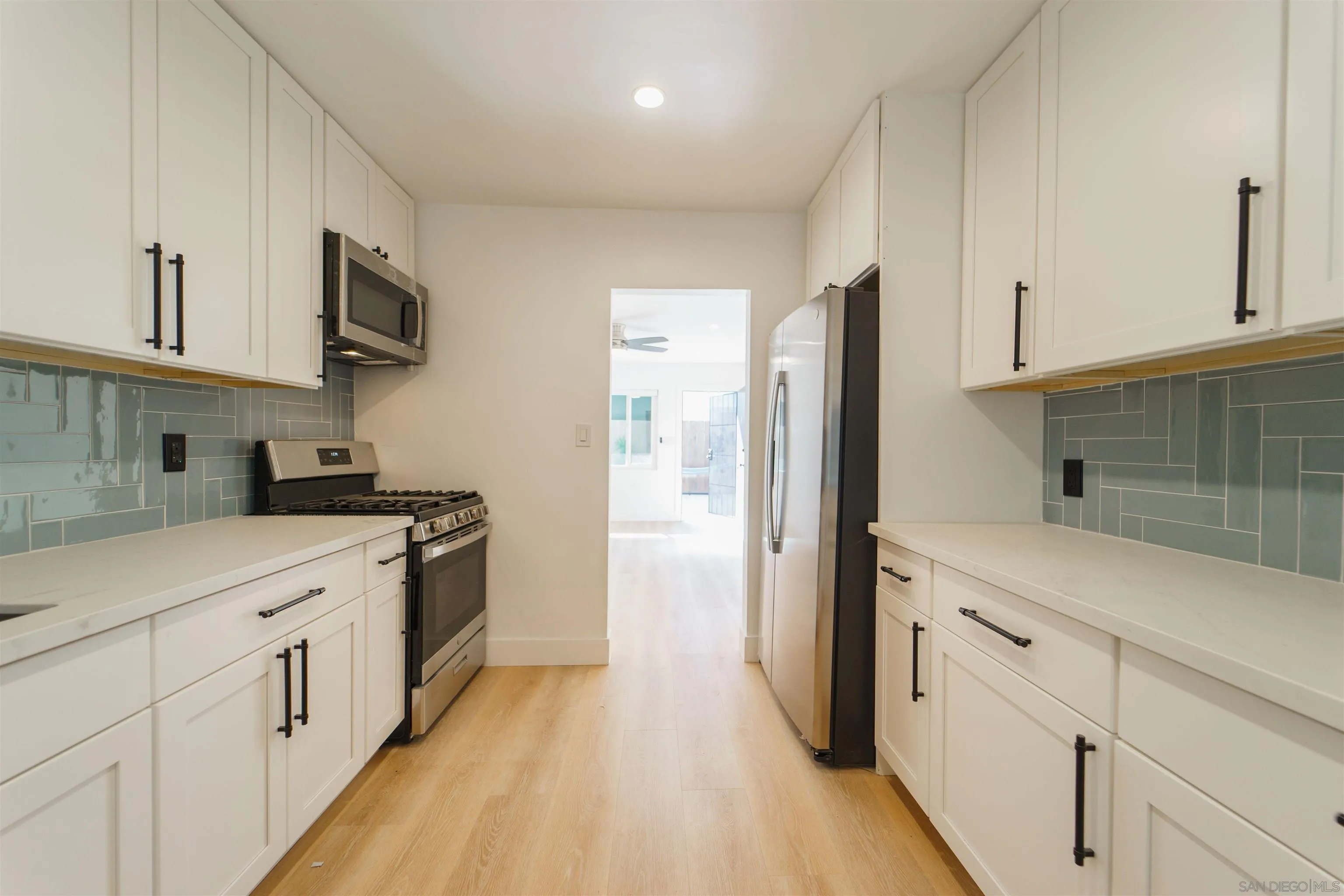 4518-24 Kansas Street San Diego, CA 92116 - Photo 22 of 33 a kitchen with cabinets stainless steel appliances a sink and wooden floor