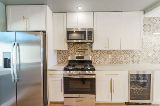 a kitchen with white cabinets and window