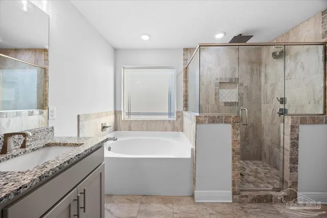 a bathroom with a granite countertop bathtub shower sink and mirror