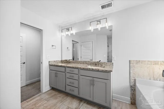 a bathroom with a granite countertop sink a mirror and a shower