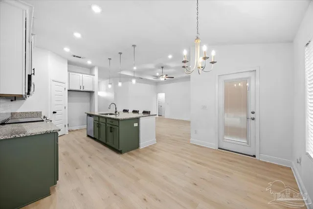 a large kitchen with stainless steel appliances granite countertop a large counter top a sink and a refrigerator