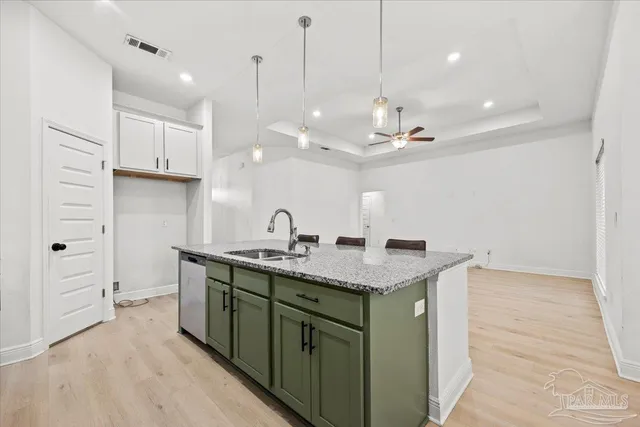 a kitchen with a sink a center island a counter space and cabinets