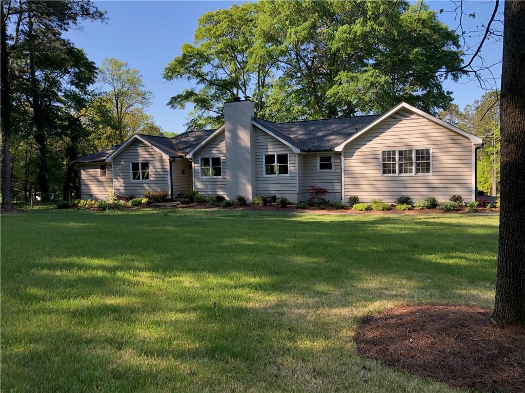 2238 Lenora Road Loganville, GA 30052 - Photo 1 of 1 a front view of a house with a yard and trees