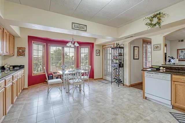 a dining hall with stainless steel appliances granite countertop a stove and a refrigerator